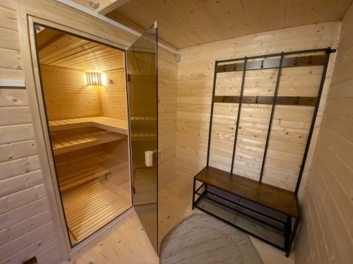 Innenansicht einer Sauna mit Duschbereich und Holzregal.
