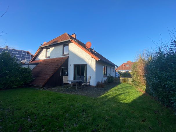 Hinteransicht eines Hauses mit Garten und blauer Himmel.